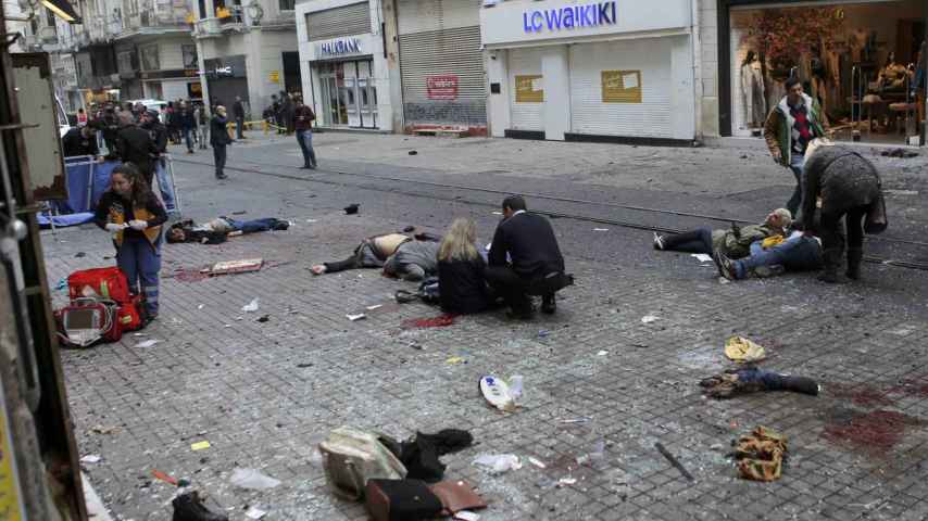 Varias personas atienden a algunos de los heridos en la explosión.