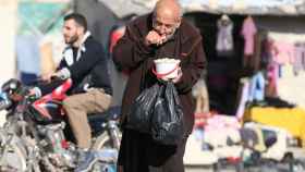 A file photo shows a man eating food that was distributed as aid in a rebel-held besieged area in Aleppo