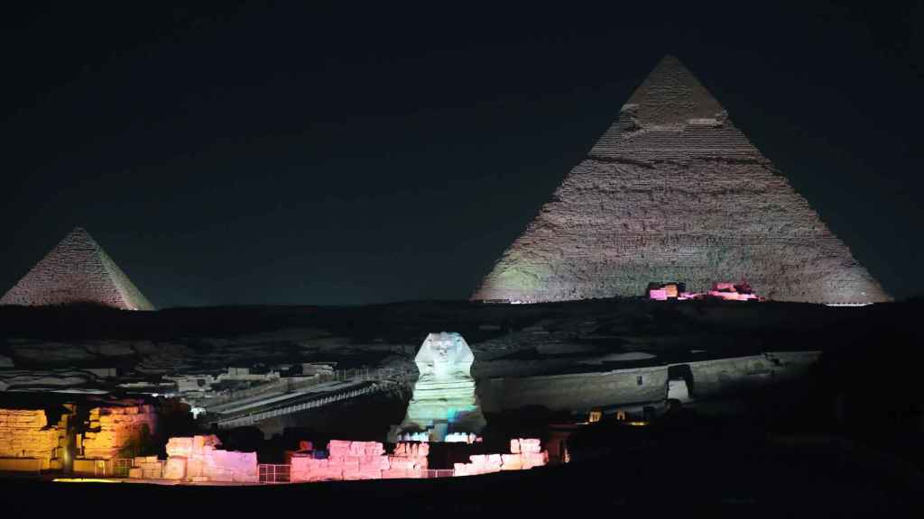La Gran Esfinge de Guiza se ilumina frente a las Grandes Pirámides durante un espectáculo.
