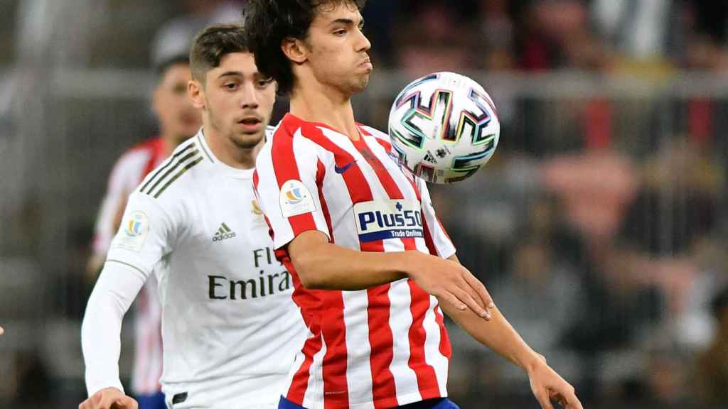 Joao Felix controla el balón con el pecho, presionado por Fede Valverde